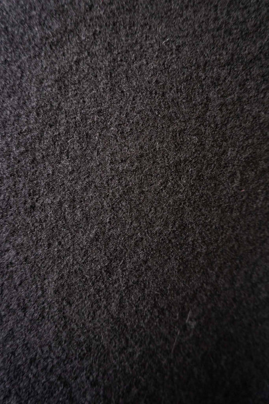 Skulpturaler schwarzer Poncho aus gewalkter Wolle mit oversized Schnitt