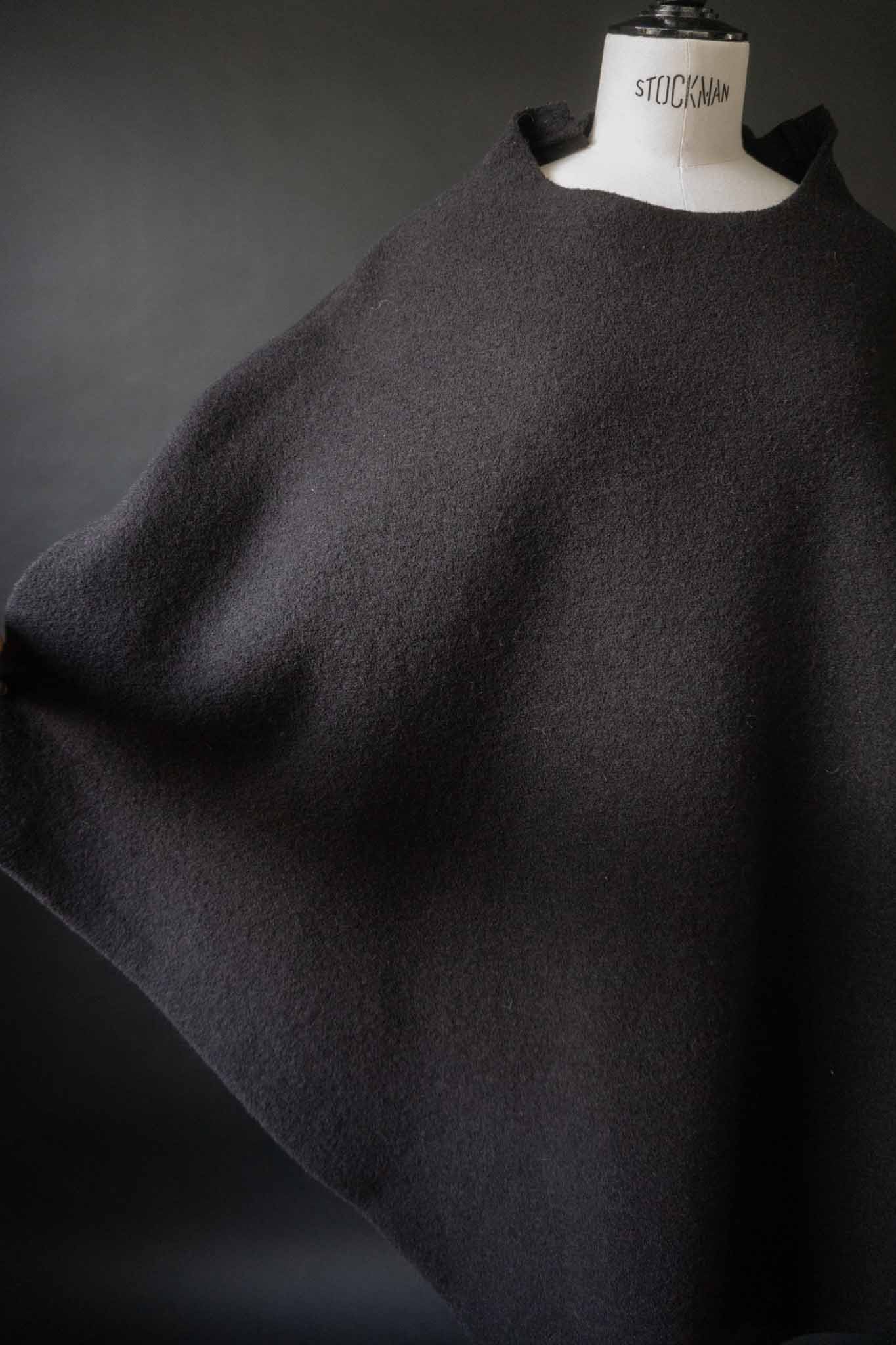 Skulpturaler schwarzer Poncho aus gewalkter Wolle mit oversized Schnitt