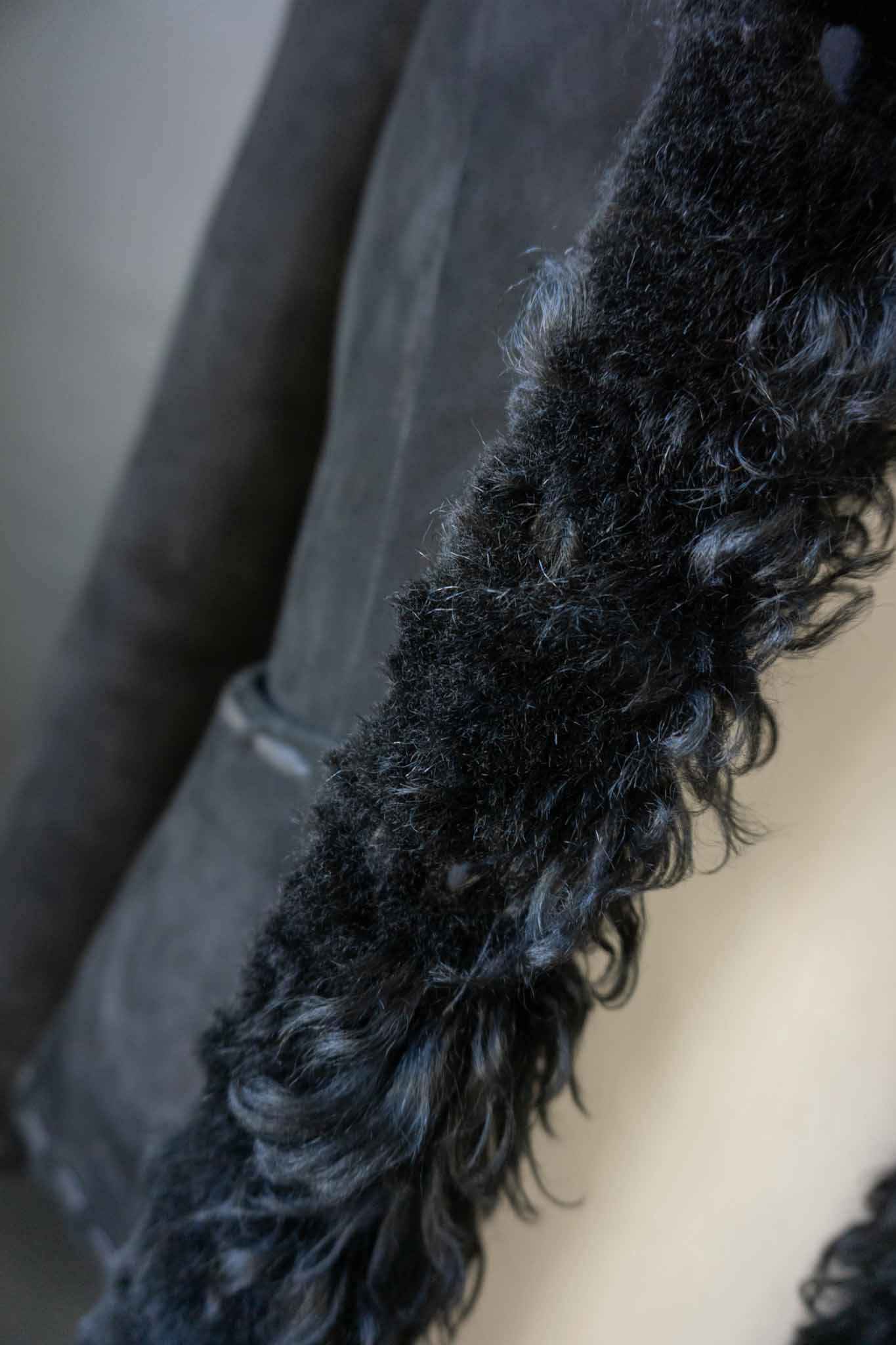 schwarze Vintage Lammfelljacke aus Echtleder mit breitem Fellkragen und Fellumschlägen an den Ärmeln