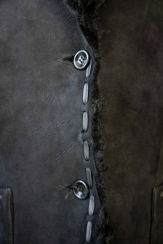 schwarze Vintage Lammfelljacke aus Echtleder mit breitem Fellkragen und Fellumschlägen an den Ärmeln