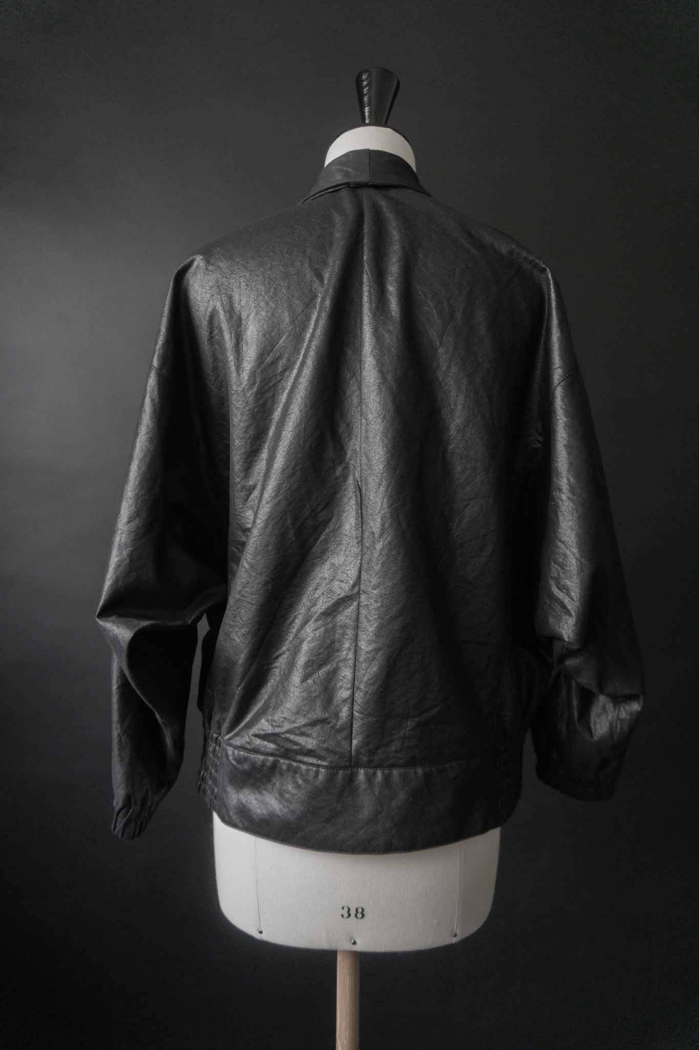 Schwarze Vintage Blousonjacke mit Steppnähten und Fledermausärmeln auf schwarzem Hintergrund