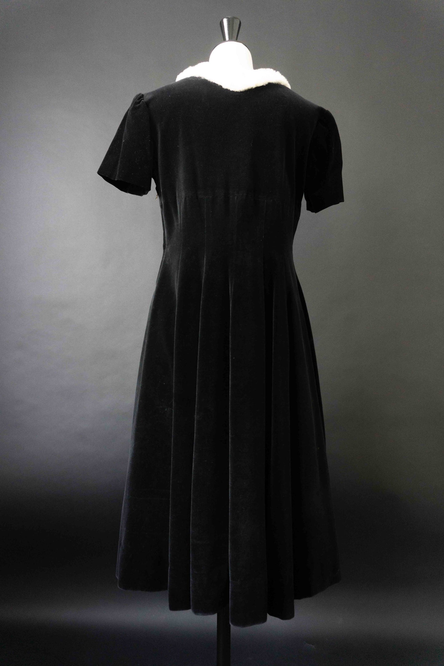 Vintage Samtkleid schwarz aus den späten 60er Jahren mit weißem Fellkragen und seitlichem Metallreißverschluss