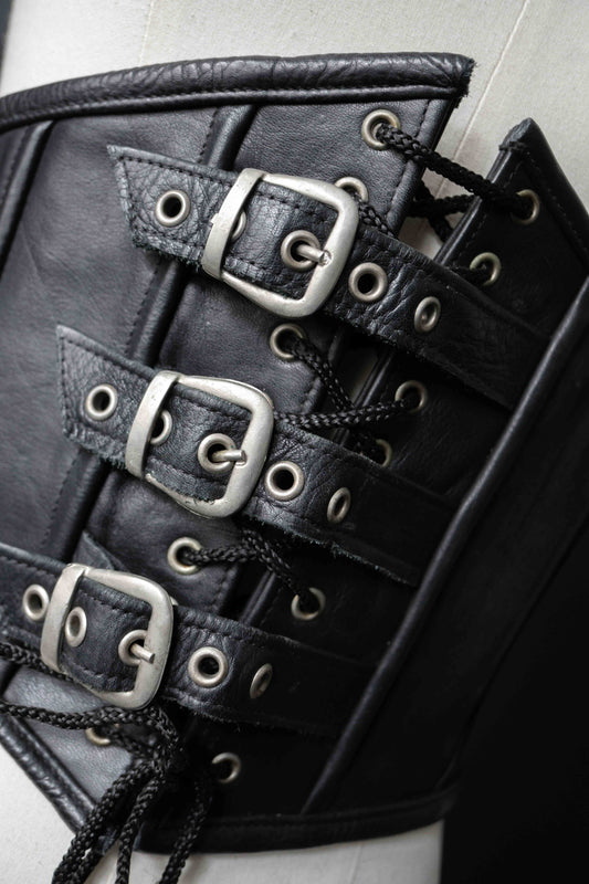 Schwarzer Leder-Corsagen-Gürtel mit vier Schnallen vorn und Reißverschluss hinten.