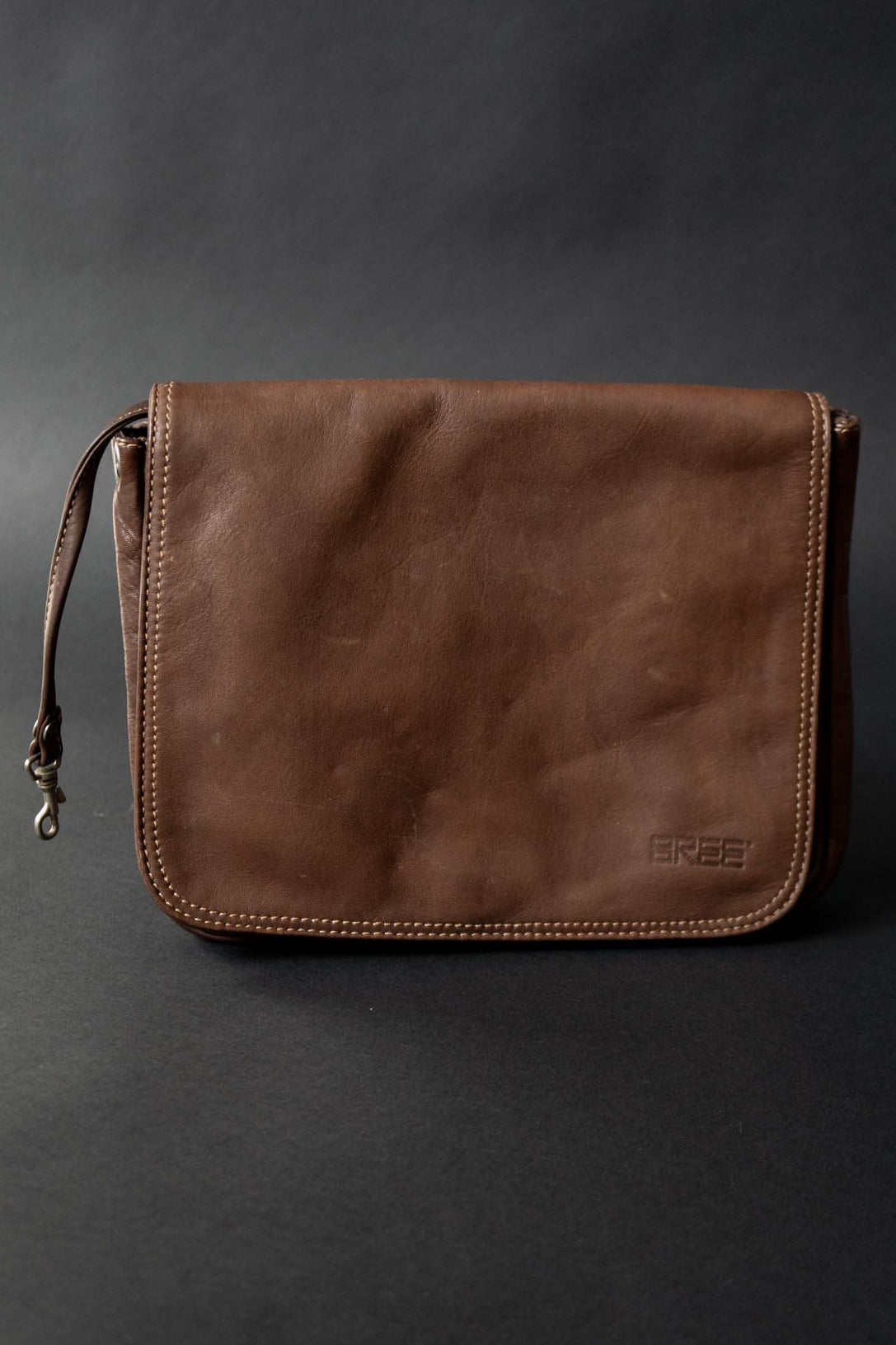 Braune Vintage Ledertasche von BREE mit Klappe und seitlichen Ösen für Schultergurt
