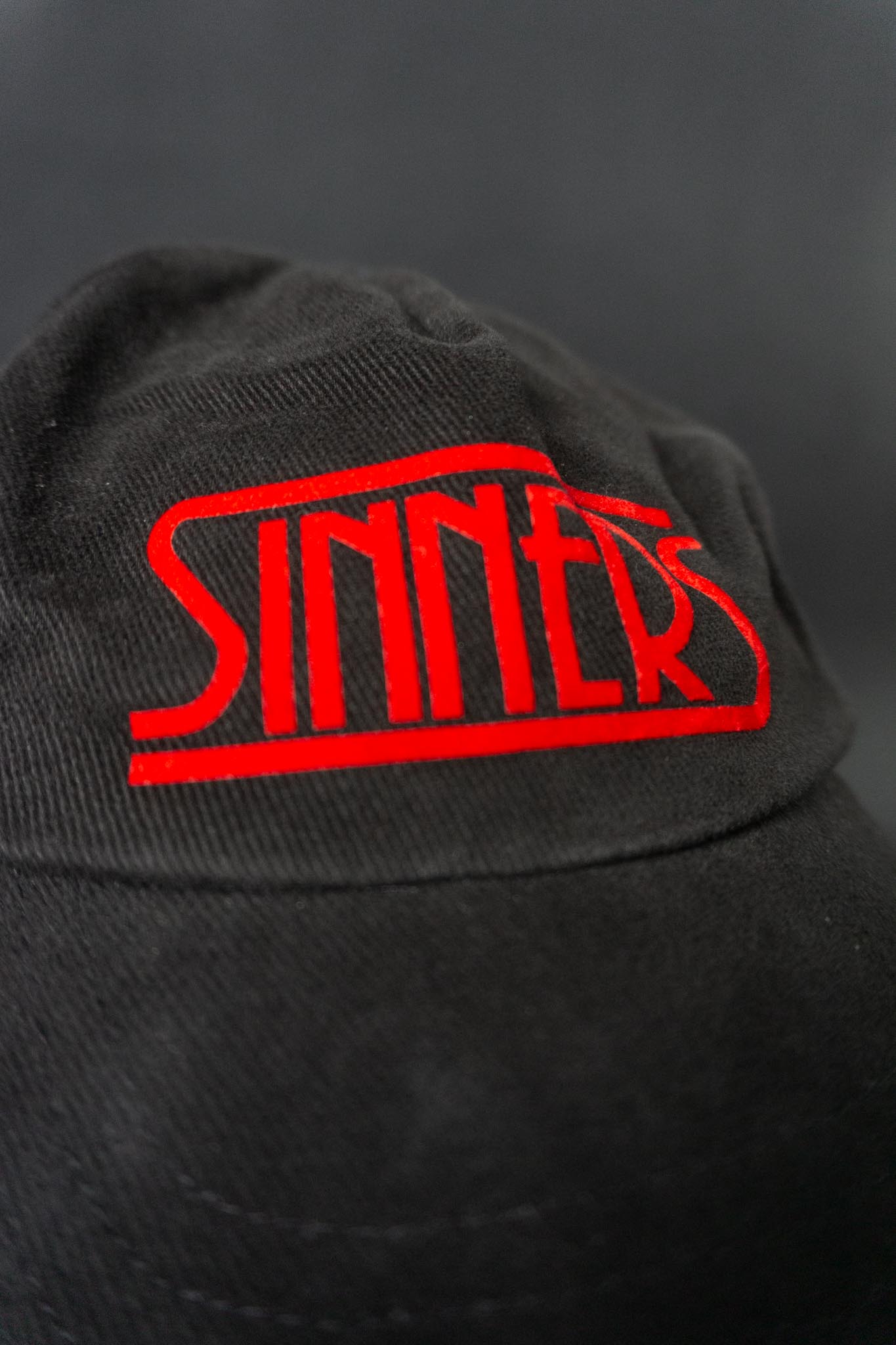 Vintage “Sinners” Baseball Cap – schwarze Baumwoll-Cap mit rotem Statement-Logo