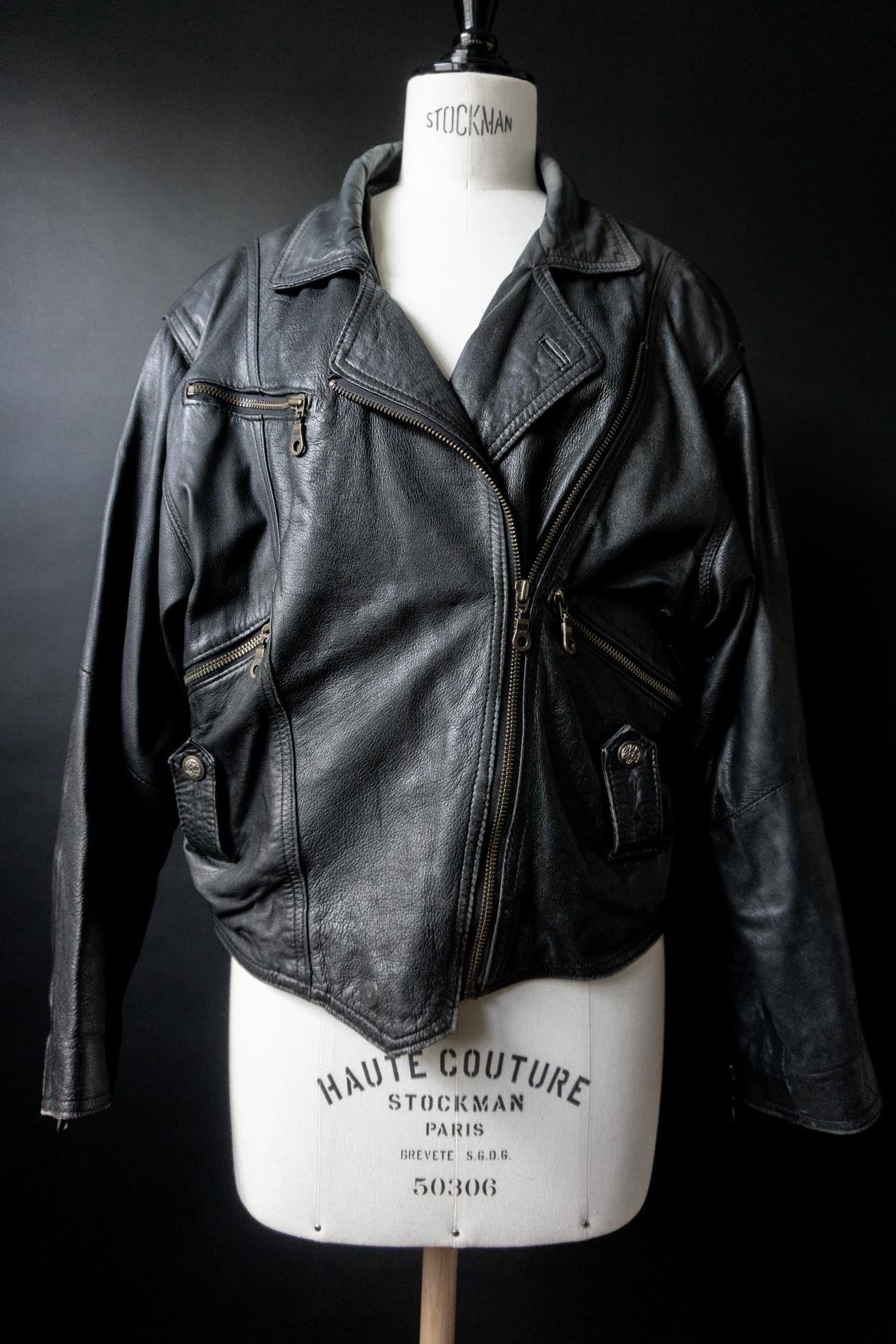 Schwarze Vintage Bikerjacke aus Echtleder mit asymmetrischem Reißverschluss und authentischer Patina.