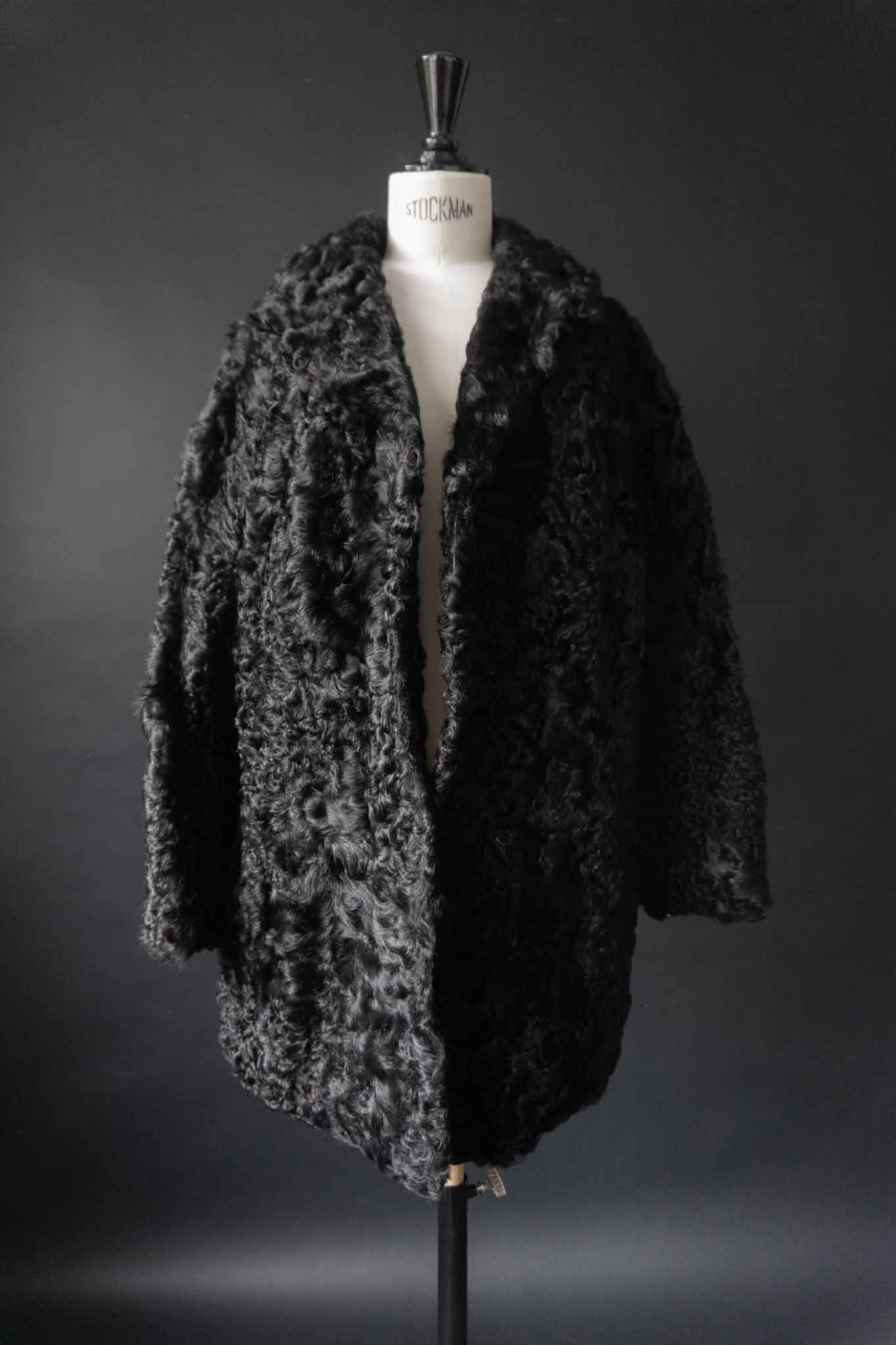 Schwarzer Vintage Lammfellmantel aus den 60er Jahren mit Hakenverschlüssen – echtes Lammfell, handverlesen bei theplaincircle vintage