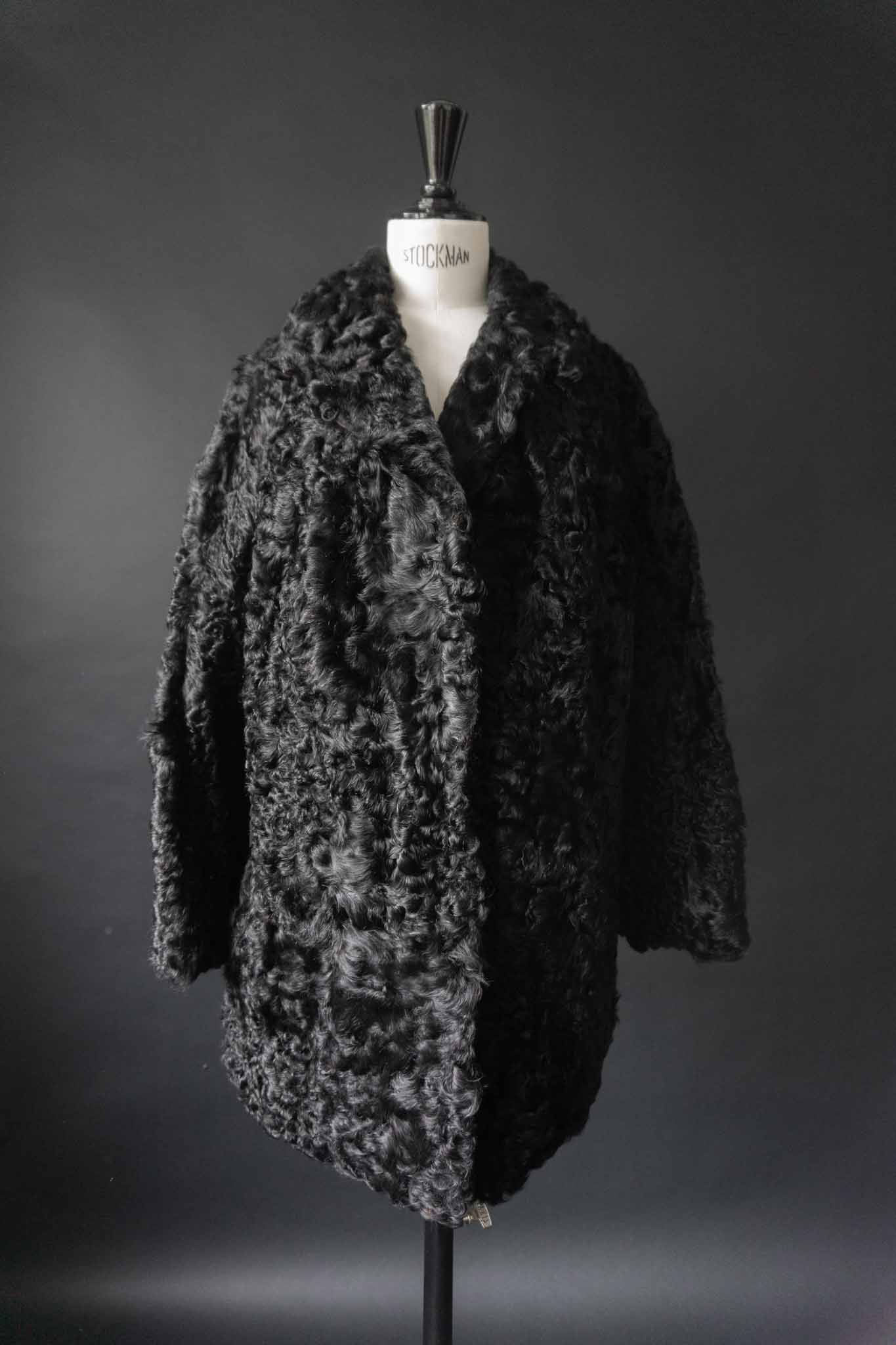 Schwarzer Vintage Lammfellmantel aus den 60er Jahren mit Hakenverschlüssen – echtes Lammfell, handverlesen bei theplaincircle vintage