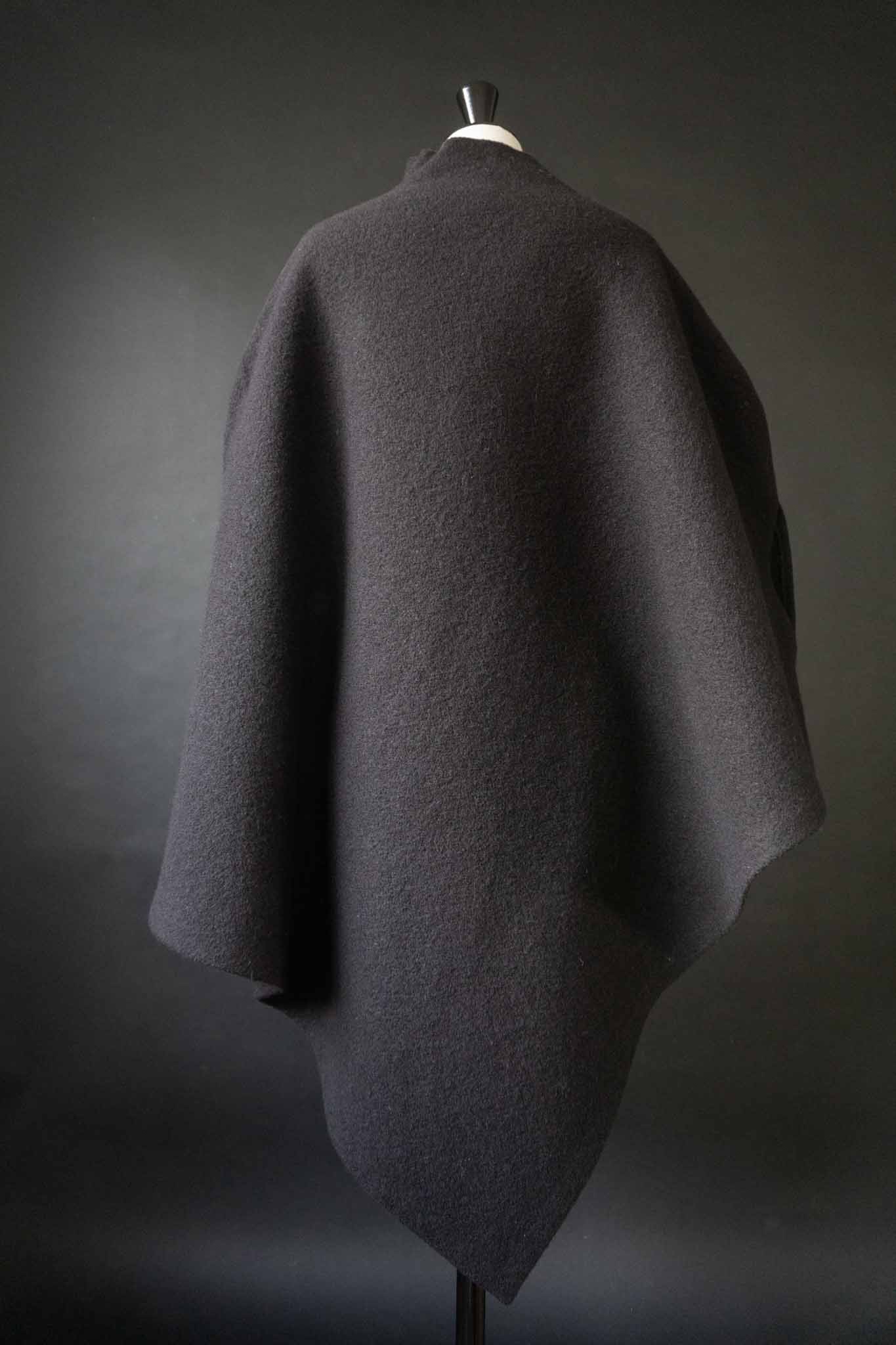 Skulpturaler schwarzer Poncho aus gewalkter Wolle mit oversized Schnitt