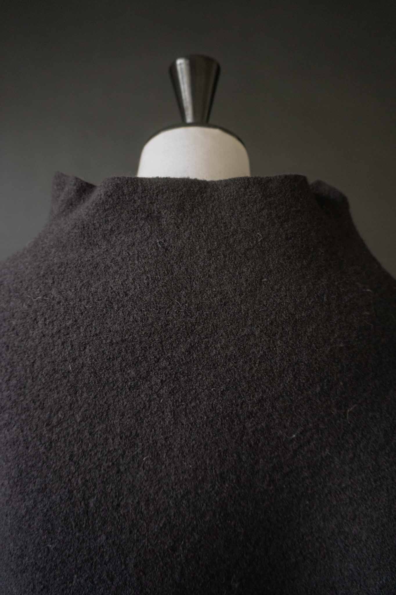 Skulpturaler schwarzer Poncho aus gewalkter Wolle mit oversized Schnitt