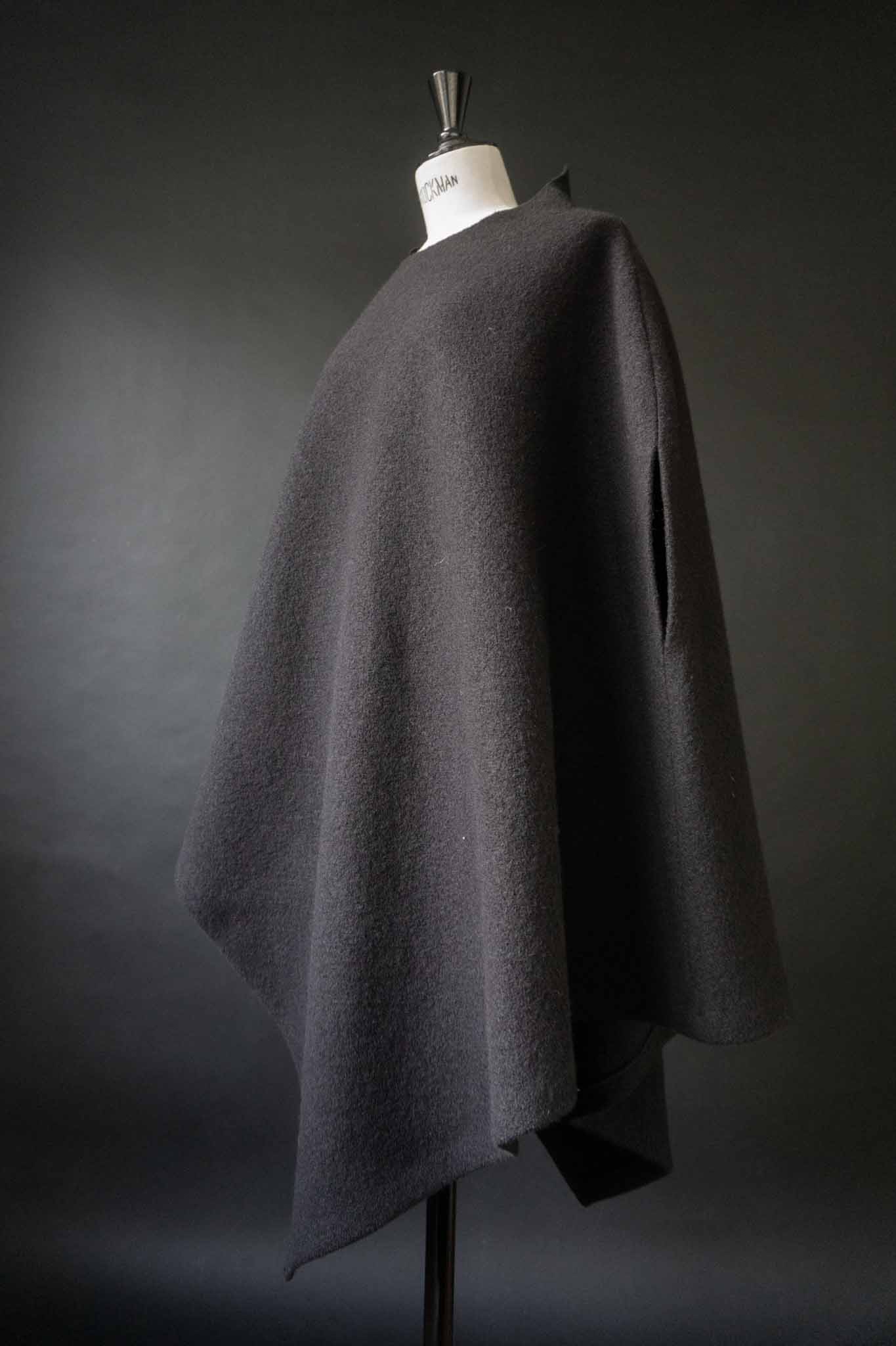 Skulpturaler schwarzer Poncho aus gewalkter Wolle mit oversized Schnitt