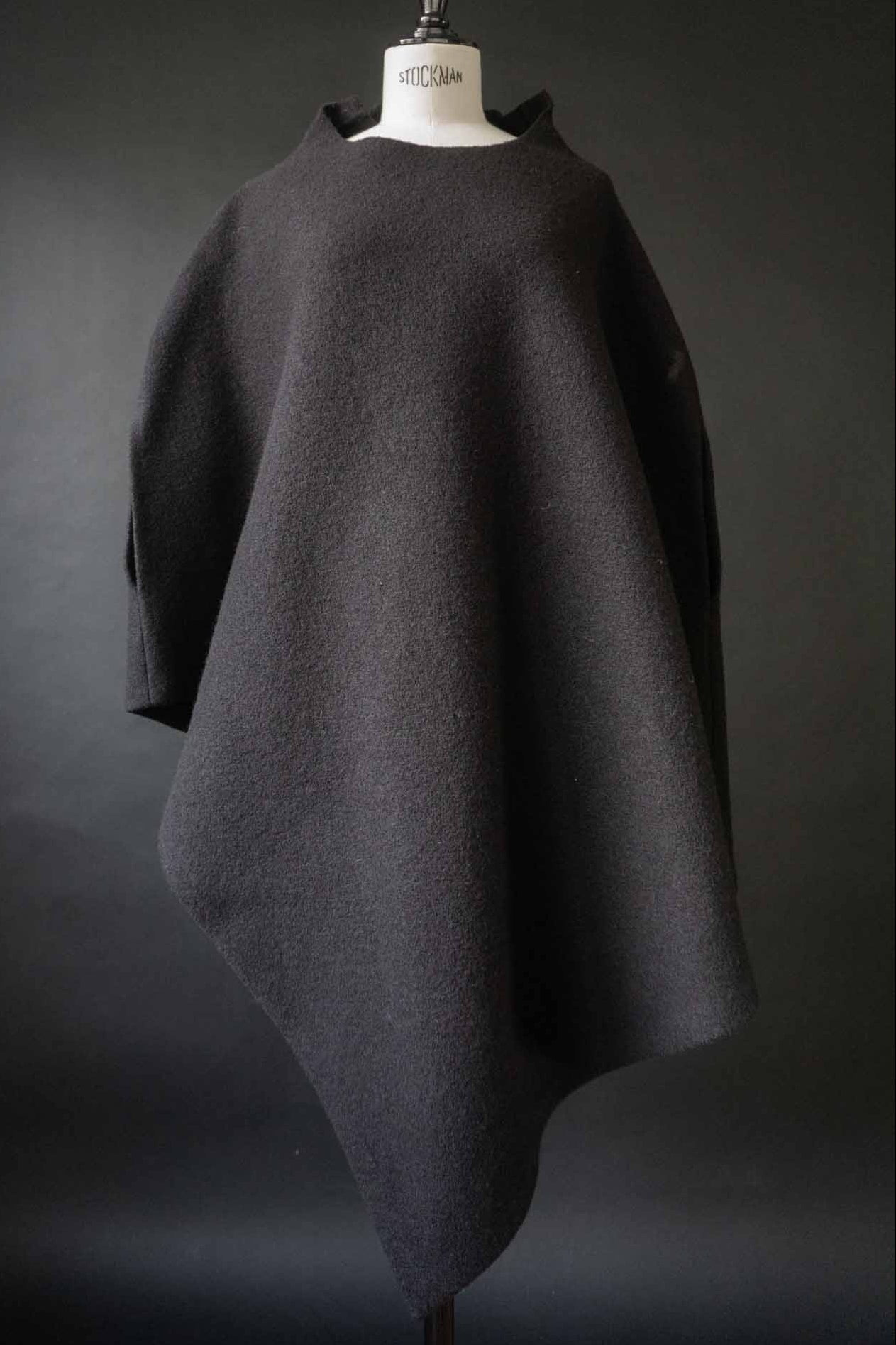 Skulpturaler schwarzer Poncho aus gewalkter Wolle mit oversized Schnitt