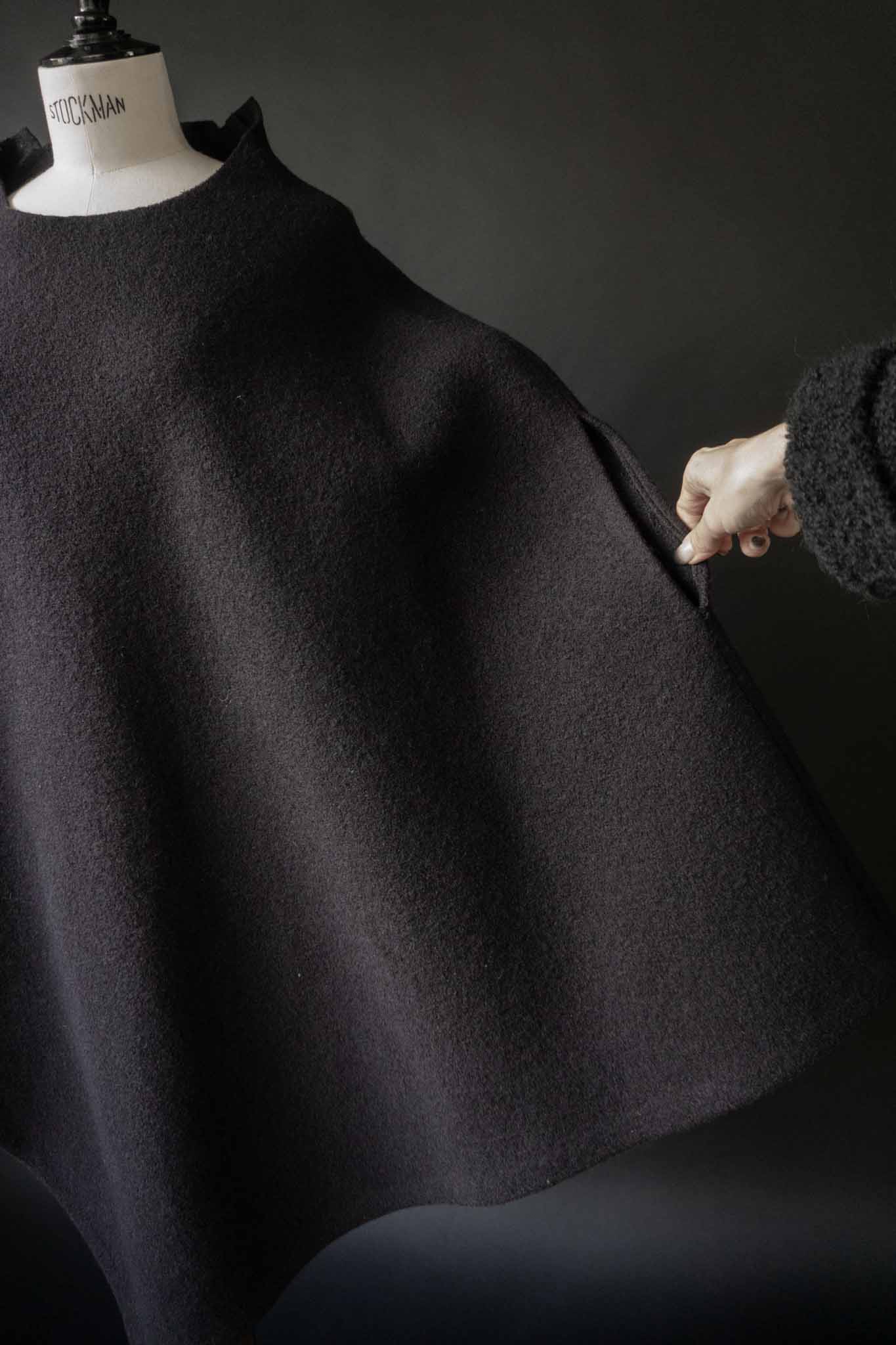 Skulpturaler schwarzer Poncho aus gewalkter Wolle mit oversized Schnitt