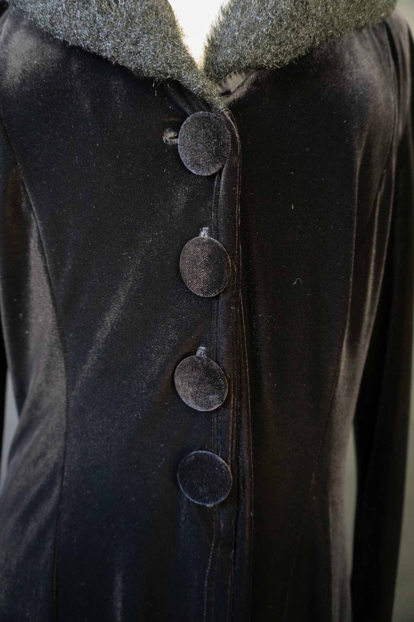 Langer schwarzer Vintage Samtmantel mit flauschigem Kragen und Manschetten in Felloptik, stoffbezogenen Knöpfen und Schlitz vorne und hinten – theplaincircle vintage
