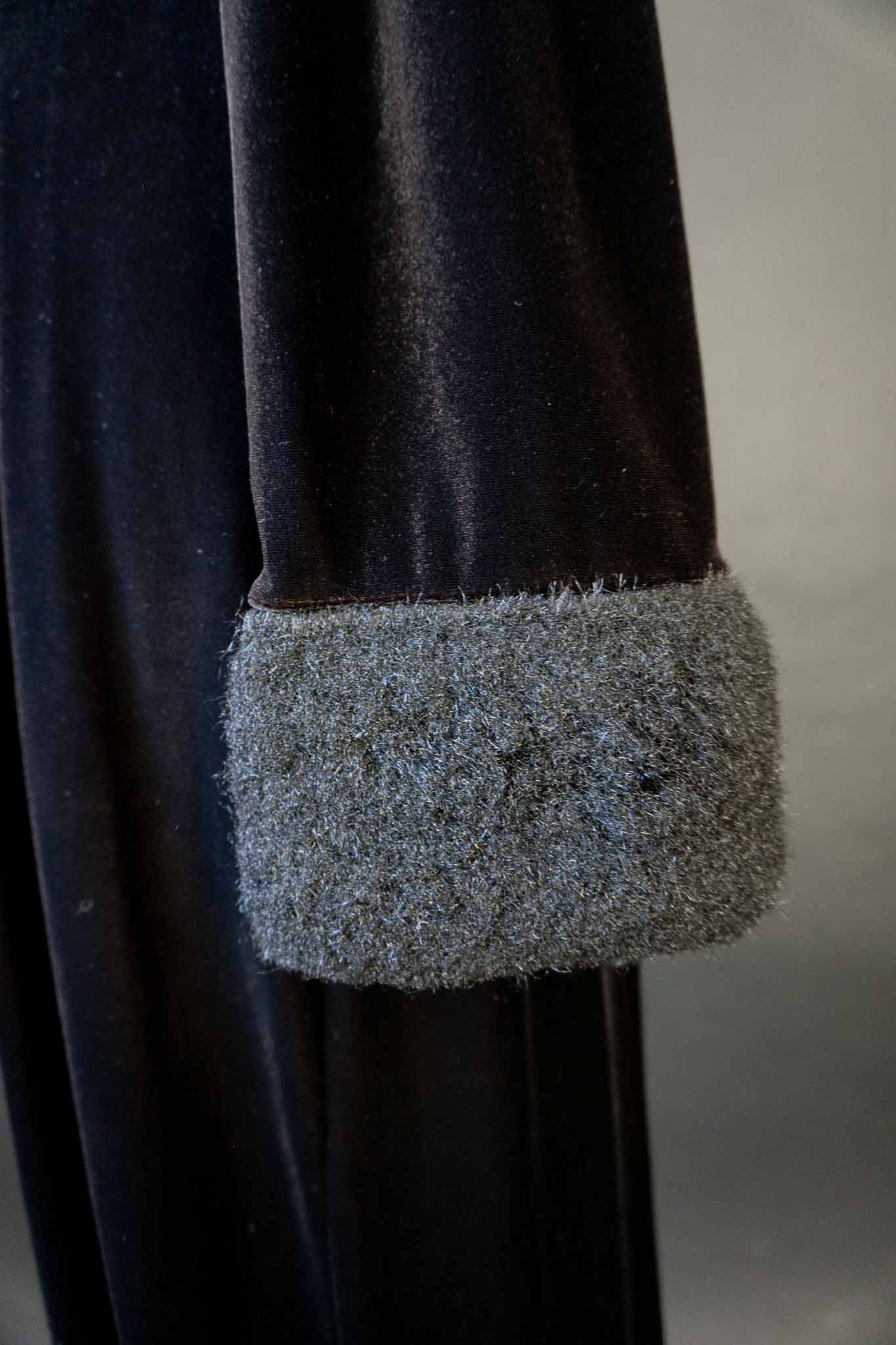 Langer schwarzer Vintage Samtmantel mit flauschigem Kragen und Manschetten in Felloptik, stoffbezogenen Knöpfen und Schlitz vorne und hinten – theplaincircle vintage