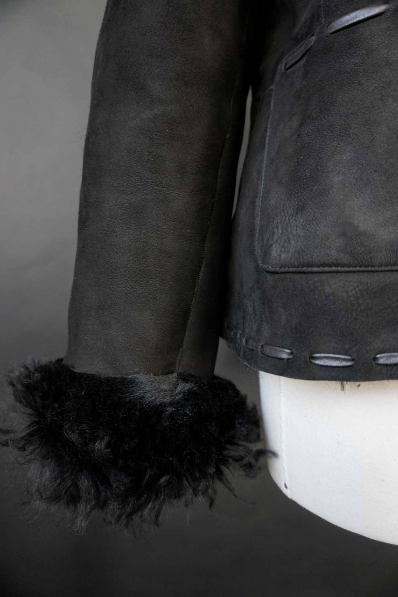 schwarze Vintage Lammfelljacke aus Echtleder mit breitem Fellkragen und Fellumschlägen an den Ärmeln