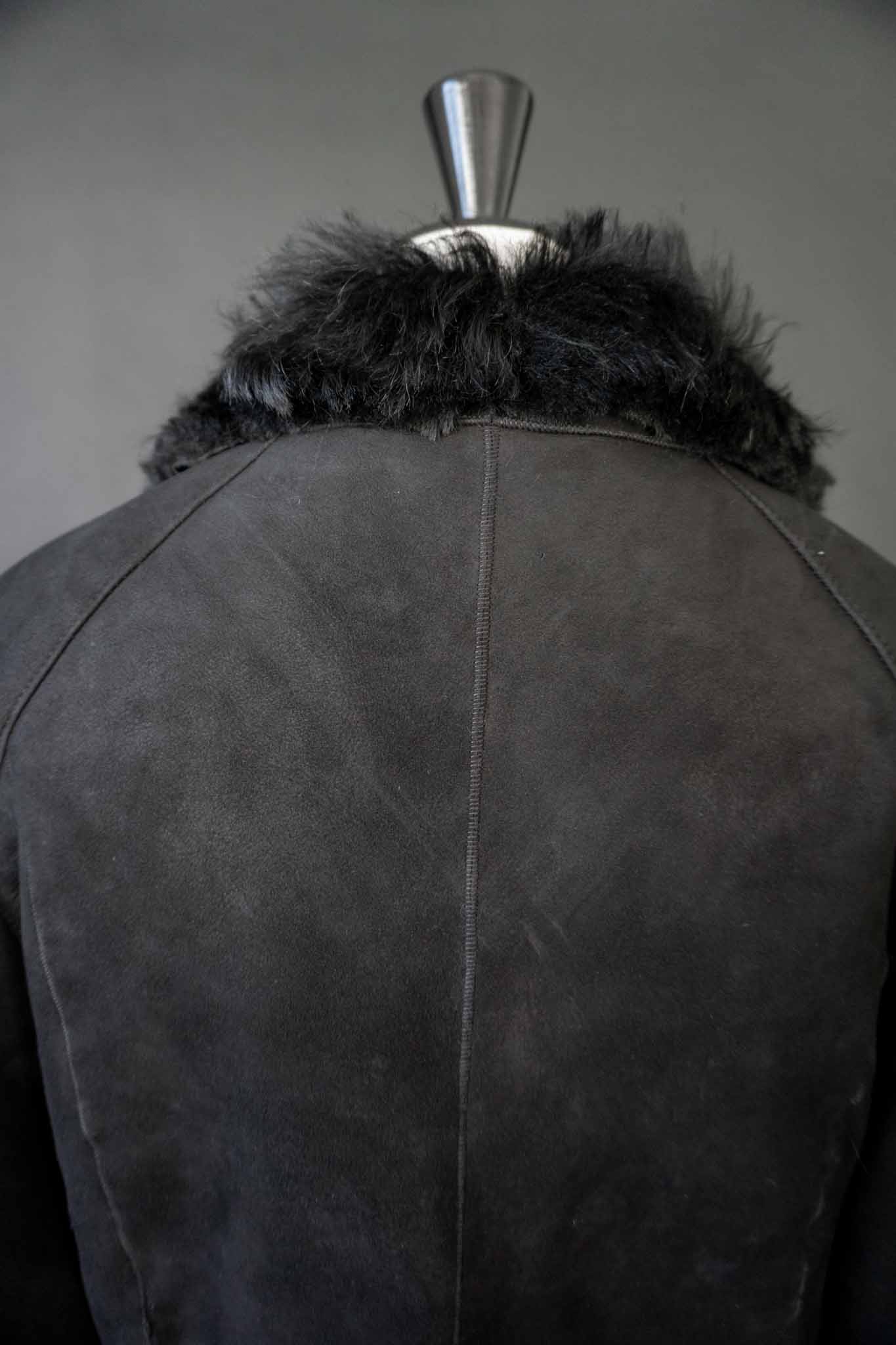 schwarze Vintage Lammfelljacke aus Echtleder mit breitem Fellkragen und Fellumschlägen an den Ärmeln