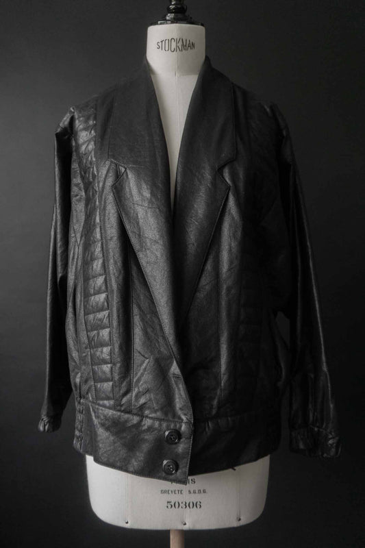 Schwarze Vintage Blousonjacke mit Steppnähten und Fledermausärmeln auf schwarzem Hintergrund