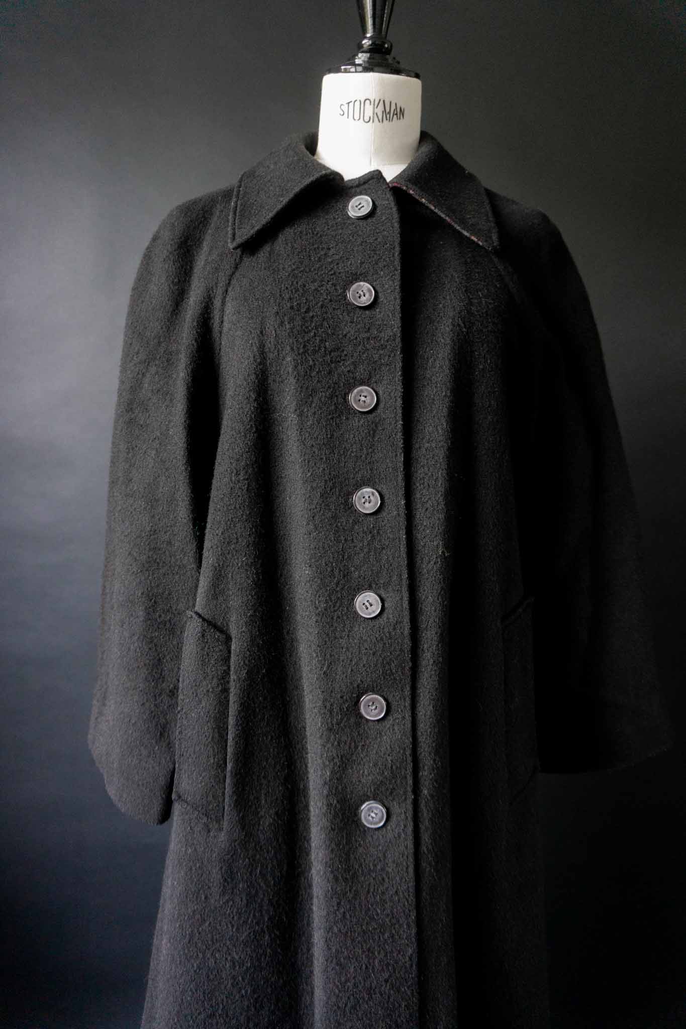 Schwarzer Vintage-Mantel von Kemper aus den 70ern mit Rückenklappe und langer Knopfleiste, aus Wollmix