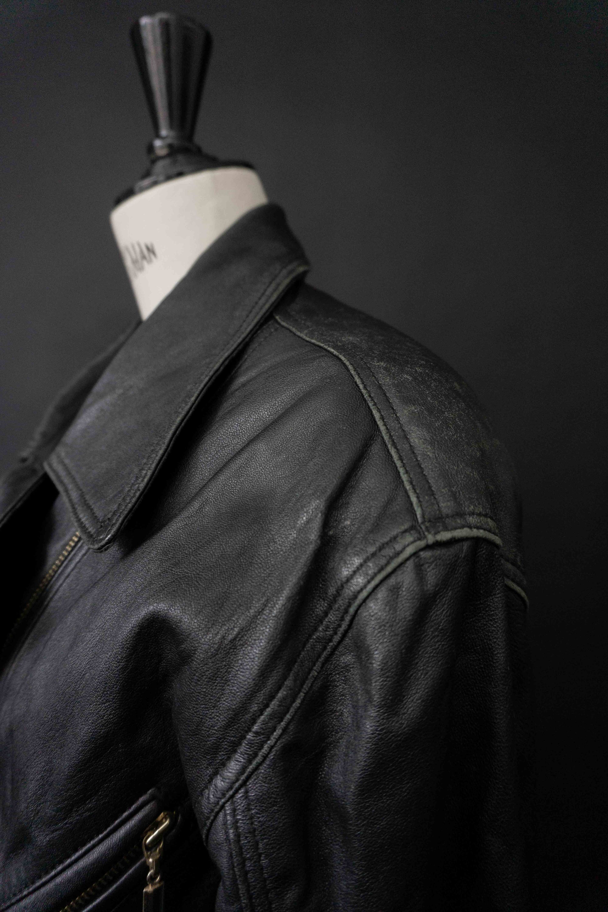 Schwarze taillierte Vintage Echtlederjacke mit Gürtel und goldenen Reißverschlüssen 