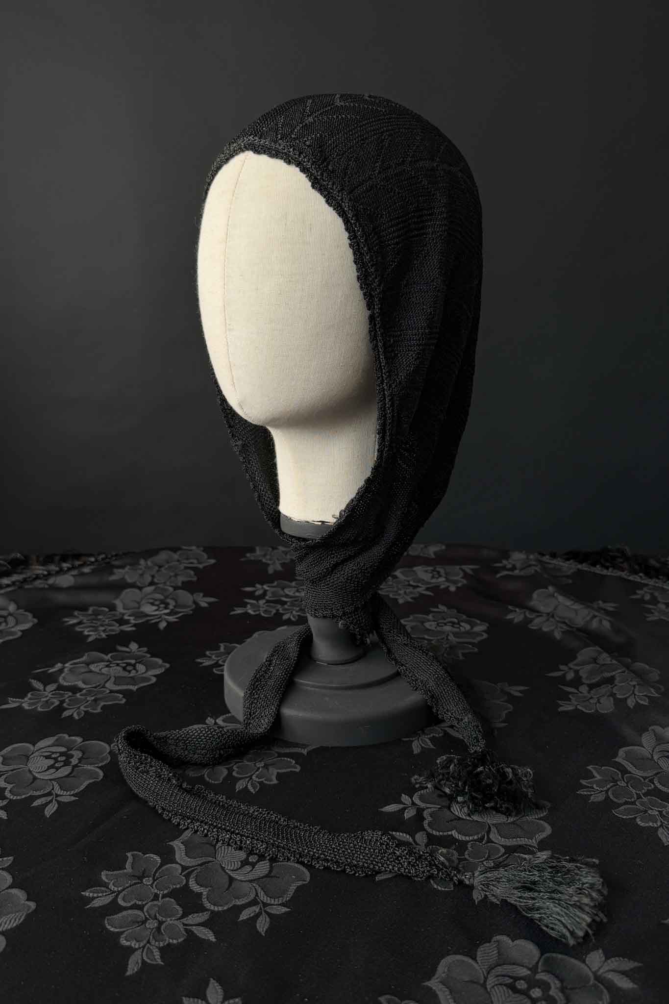 Antike schwarze Strickhaube mit langen Bindebändern
