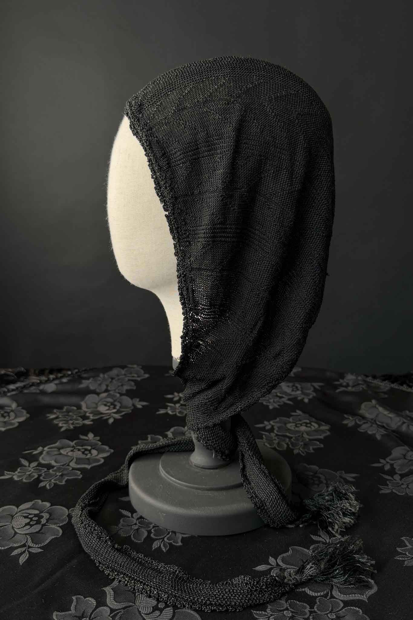 Antike schwarze Strickhaube mit langen Bindebändern