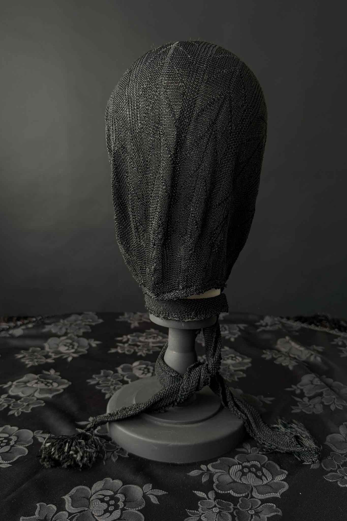 Antike schwarze Strickhaube mit langen Bindebändern
