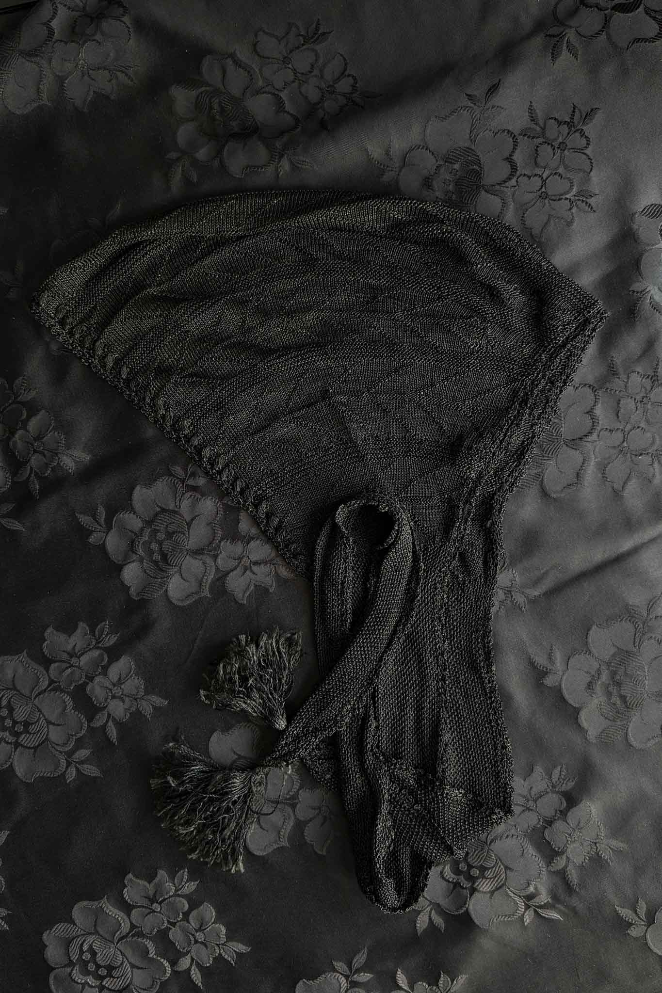 Antike schwarze Strickhaube mit langen Bindebändern