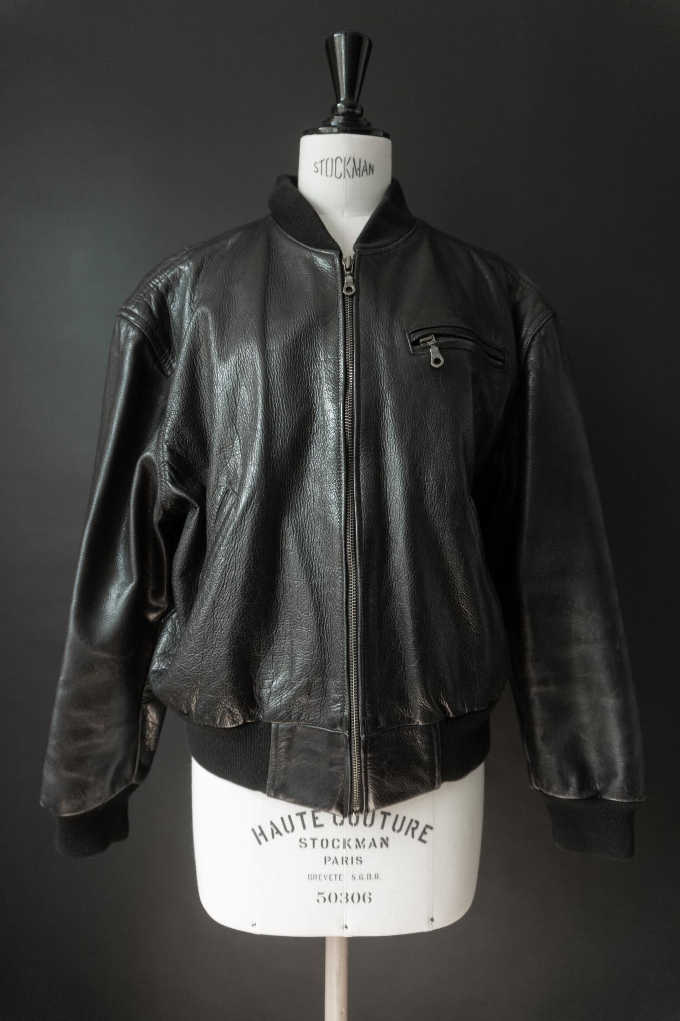 Schwarze Vintage Bomberjacke aus Echtleder mit silbernem Reißverschluss und gerippten Strickbündchen.