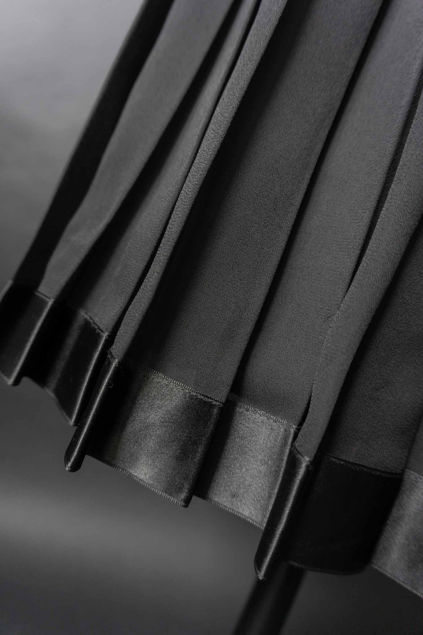 Schwarzer Vintage-Faltenrock mit Satin-Saum