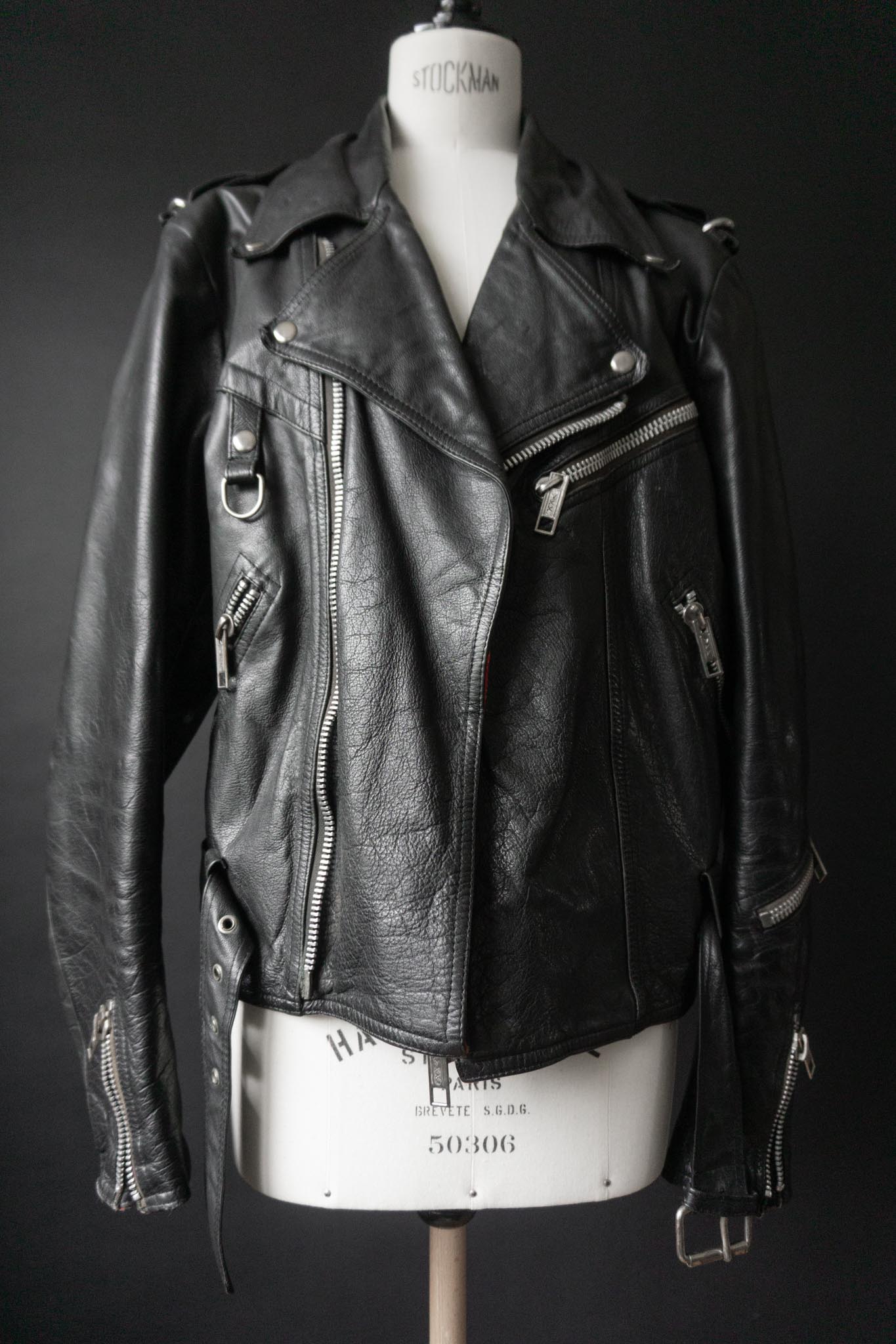Schwarze Vintage Bikerjacke mit silbernen Reißverschlüssen und Kette am Rücken