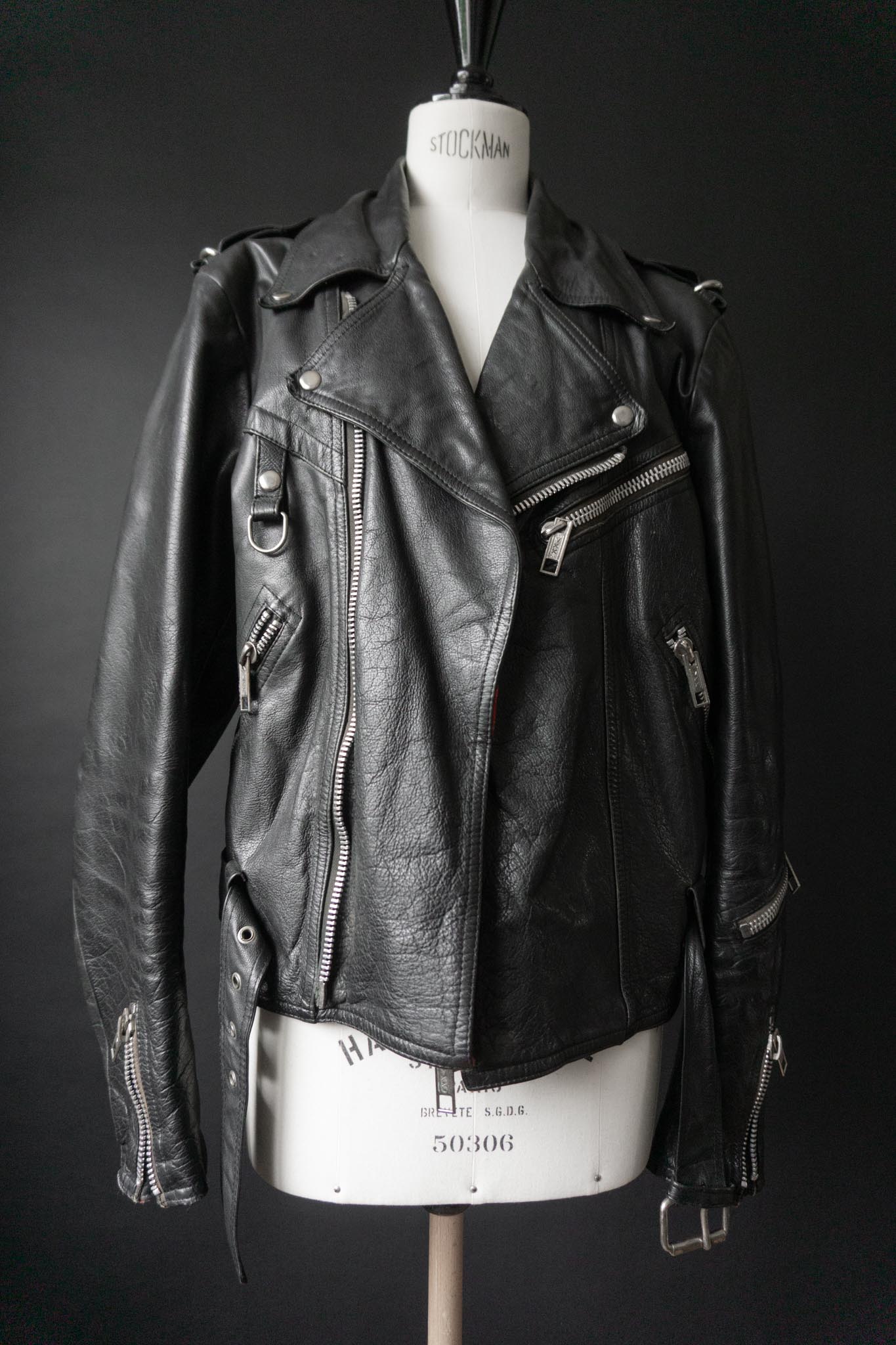 Schwarze Vintage Bikerjacke mit silbernen Reißverschlüssen und Kette am Rücken