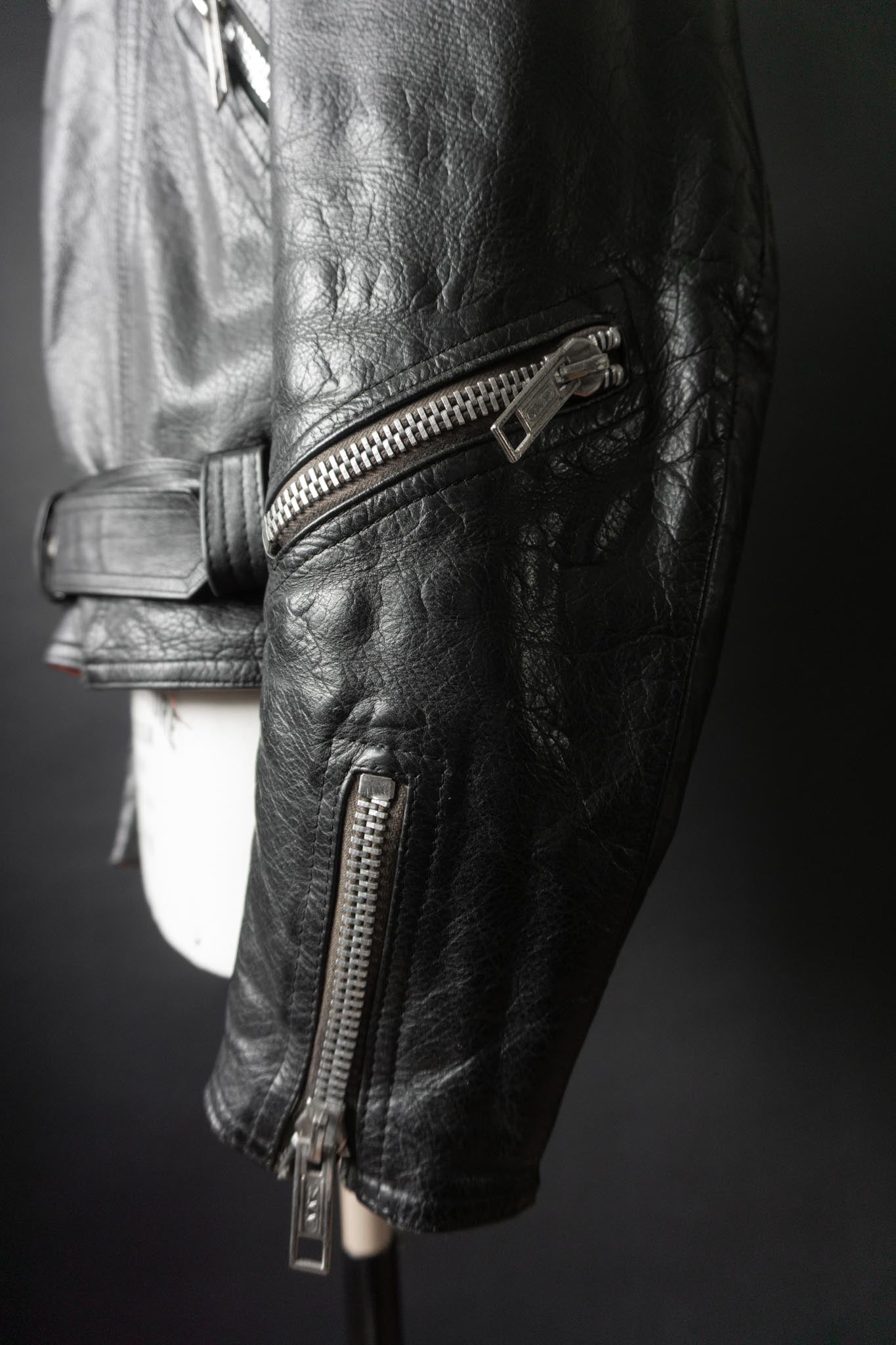 Schwarze Vintage Bikerjacke mit silbernen Reißverschlüssen und Kette am Rücken