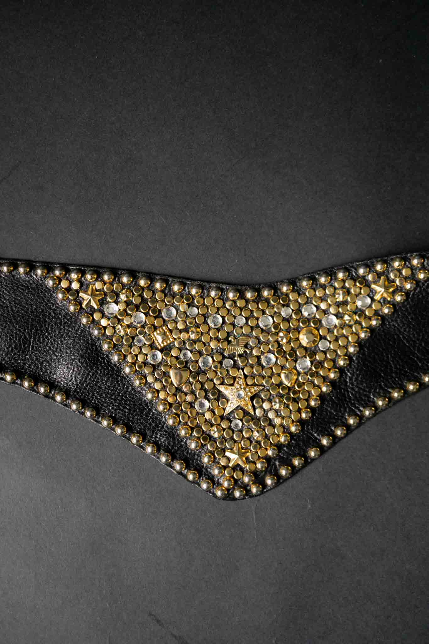 Breiter schwarzer Kolster Ledergürtel mit goldenen Nieten und dreieckigem Frontpanel.