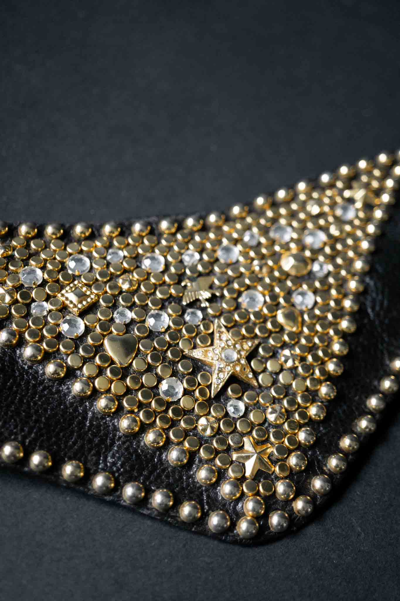 Breiter schwarzer Kolster Ledergürtel mit goldenen Nieten und dreieckigem Frontpanel.